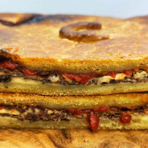 Foto detalle de una empanada de cecina de León recién hecha en Domus Panis