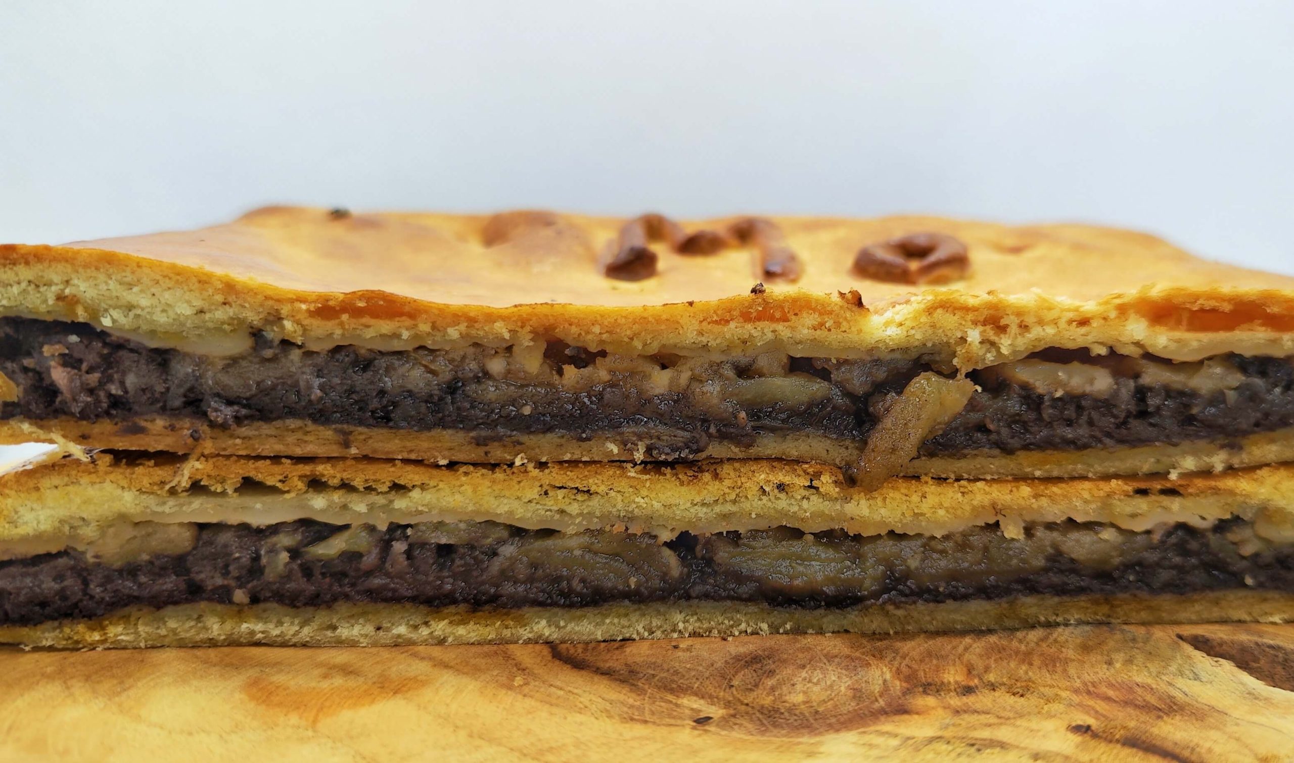 Foto detalle de una empanada de morcilla recién hecha en Domus Panis