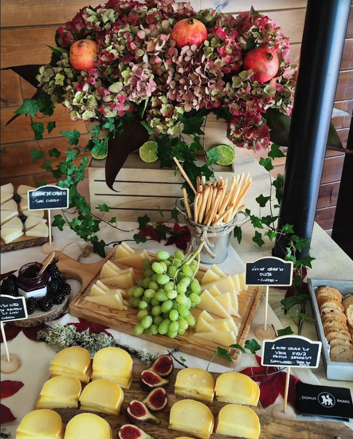 Mesa de quesos y sus complementos para combinar sus sabores.